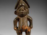 une figurine en bois représentant un homme avec un chapeau sur la tête