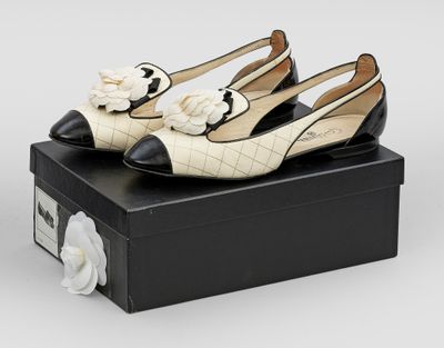 une paire de chaussures blanches et noires posée sur une boîte noire