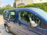 a small blue van parked in a parking lot