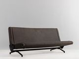 une image représentant un canapé marron posé sur une surface blanche