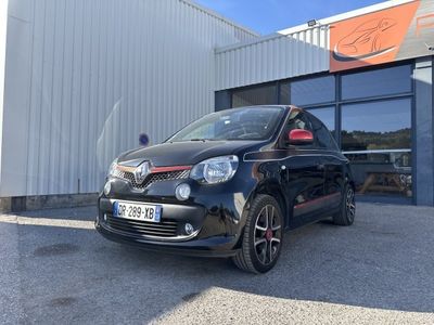 une photo d'une petite voiture noire garée devant un immeuble