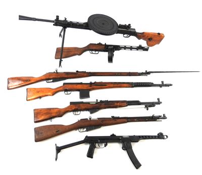 several different types of guns are lined up on a white surface