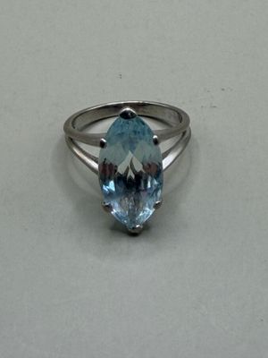 un gros plan d'une bague sertie d'une topaze bleue
