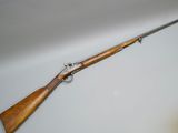 a rifle with a wooden handle on a white surface