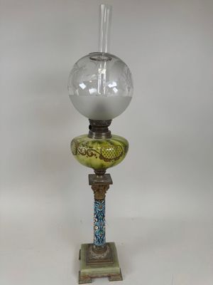 an old fashioned oil lamp with a glass shade on top of it