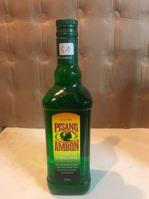 a bottle of green liquid sitting on a table