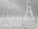 three glasses and a decanter sitting on a table