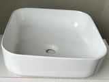 a white square sink sitting on top of a white counter