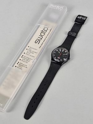 an image of a watch sitting next to a plastic box on top of a table