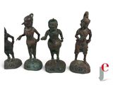 four bronze figurines of a woman and a man with a dog