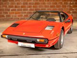 a red sports car parked in front of a brick wall
