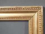 an antique gold frame with a decorative pattern on a gray background