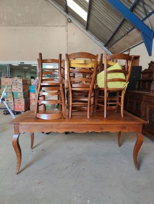 several chairs and a table in a room with a lot of furniture