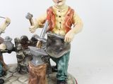 a figurine of two men working on a piece of metal