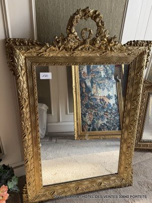 a large mirror sitting on the floor next to a vase