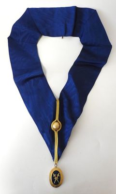 un gros plan sur une écharpe bleue ornée d'une médaille en or