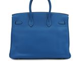 a blue leather handbag on a white background