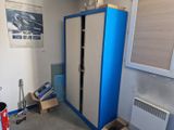 a blue and white cabinet in a room with a radiator and a heater