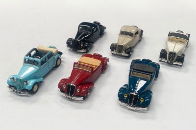 plusieurs petites voitures sont alignées sur une surface blanche
