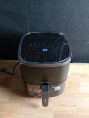 une poubelle noire posée sur une table en bois