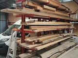 une grande pile de bois dans un garage, à côté d'une voiture