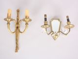 two sconces that are on the wall with a mirror