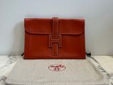 brown leather handbag sitting on top of a marble table