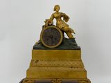 a gold clock with a statue on top of it