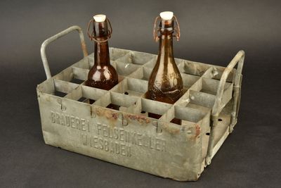 two bottles of beer in a metal crate on a table