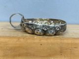 a silver bowl with a handle on a wooden table