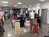 a photo of a clothing store with clothes on racks