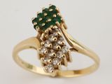 une photo en gros plan d'une bague sertie de diamants et d'une pierre verte