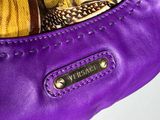 a purple purse with a gold chain hanging from it