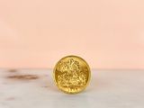 a close up of a gold coin sitting on top of a marble counter
