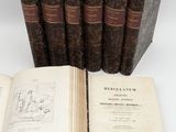 plusieurs vieux livres posés les uns sur les autres sur une table