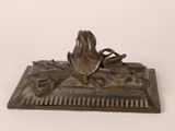 a bronze statue of a bird on top of a comb