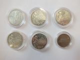 six different types of coins in plastic containers on a white surface