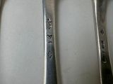 three spoons and a fork sitting on a table