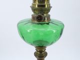 a green glass lamp that is on top of a table