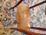 a wooden chair sitting on top of a rug on the floor