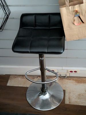 a black leather bar stool with a paper bag on it