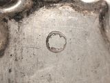 a close up of a silver vase with a hole in it