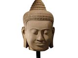 an image of a stone head of a buddha on a stand