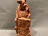 une image représentant la statue d'un homme assis sur une caisse