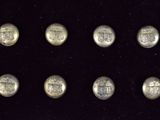 six silver buttons with a coat of arms on them on a black surface