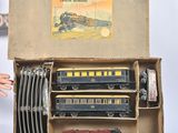 un circuit de train miniature dans une boîte en carton, avec une main qui tend vers lui