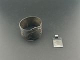 une bague en argent posée à côté d'un petit objet en métal