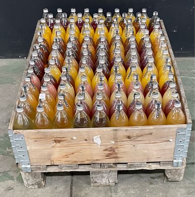 plusieurs bouteilles de jus d'orange dans une caisse en bois