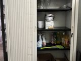 une armoire blanche avec des étagères et une horloge posée dessus