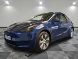 a blue tesla model y parked on a checkered floor